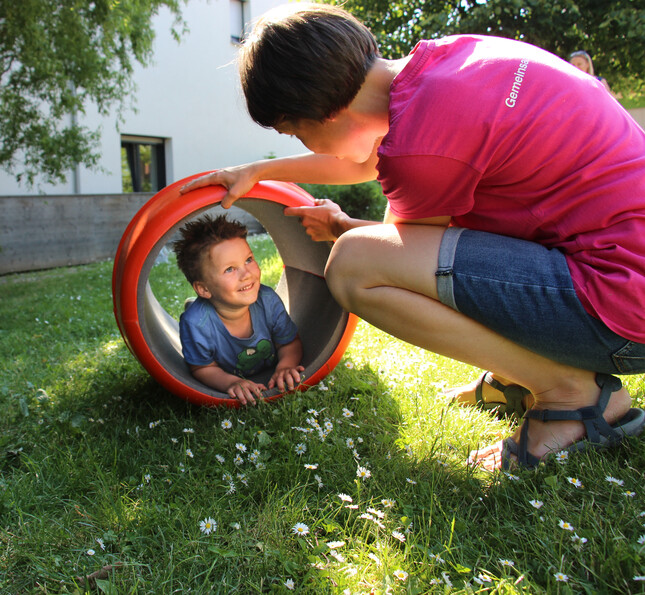 Ein Kind und eine Frau spielen im Grünen