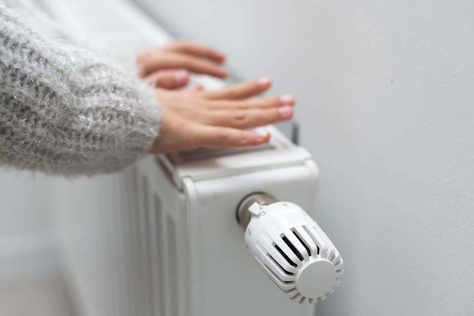 The child's hands warm their hands near the heating radiator. Saving gas in the heating season. © Andrew Angelov The,Child's,Hands,Warm,Their,Hands,Near,The,Heating,Radiator.